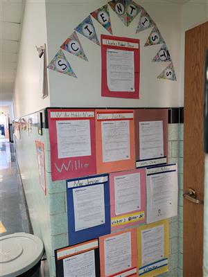 Photo of a wall covered with paper reports detailing facts about Black Americans in STEM.